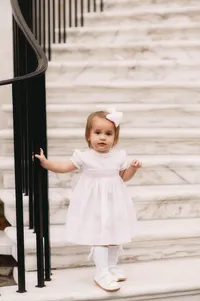 Charleston Baby Milestone Photographer - Toddler peers at the camera during Baby Milestone Portraits in downtown Charleston, SC