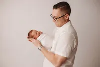 Newborn Photographer in Charleston -Father embraces his infant during Newborn Portrait Session in Charleston, SC.