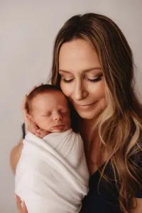 Newborn Photographer in Charleston - Mother embraces her infant during Newborn Portrait Session in Charleston, SC.