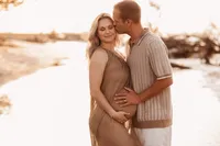 Folly Beach Maternity Photographer -- Pregnant woman poses for Maternity Photos at the Lighthouse Inlet Heritage Preserve on Folly Beach with iconic views of the Morris Island Lighthouse in the distance.
