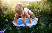 Charleston Baby Milestone Photographer - Baby plays in a splash bath during his Milestone Portrait Session at Holy City Babies Portrait Studio in Charleston, SC.