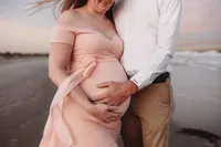 Charleston Beach Maternity Photographer -- Expectant parents pose for Maternity Photos on Folly Beach, SC.