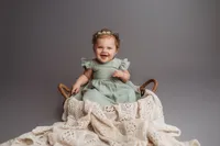 Charleston Baby Milestone Photographer - Baby smiles at the camera during his Milestone Portrait Session at Holy City Babies Portrait Studio in Charleston, SC.