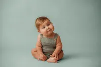Charleston Baby Milestone Photographer - Baby peers curiously at the camera during his Milestone Portrait Session at Holy City Babies Portrait Studio in Charleston, SC.