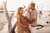 Folly Beach Maternity Photographer -- Pregnant woman poses for Maternity Photos at the Lighthouse Inlet Heritage Preserve on Folly Beach with iconic views of the Morris Island Lighthouse in the distance.