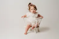 Charleston Cake Smash Photographer- Baby looks into the camera during Milestone Portraits at Holy City Babies Portrait Studio in Charleston, SC.