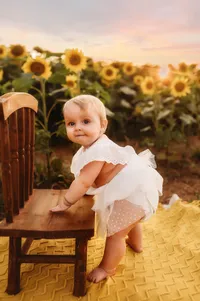 Charleston Baby Milestone Photographer - Baby grins at the camera during her Milestone Portrait Session at Holy City Babies Portrait Studio in Charleston, SC.