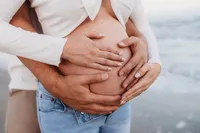 Charleston Beach Maternity Photographer -- Expectant parents pose for Maternity Photos on Folly Beach, SC.
