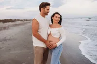 Charleston Beach Maternity Photographer -- Expectant parents pose for Maternity Photos on Folly Beach, SC.