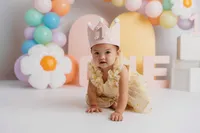 Cake Smash Photographer in Charleston, SC - Baby smiles at the camera during Cake Smash Photoshoot at Holy City Babies in Charleston, SC.
