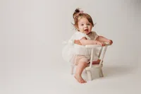 Charleston Cake Smash Photographer- Baby looks into the camera during Milestone Portraits at Holy City Babies Portrait Studio in Charleston, SC.