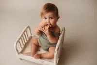 Charleston Baby Milestone Photographer - Baby slobbers on a wooden toy during his Milestone Portrait Session at Holy City Babies Portrait Studio in Charleston, SC.