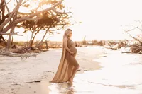 Folly Beach Maternity Photographer -- Pregnant woman poses for Maternity Photos at the Lighthouse Inlet Heritage Preserve on Folly Beach with iconic views of the Morris Island Lighthouse in the distance.