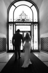 bride and groom exit under sign san francisco city hall wedding