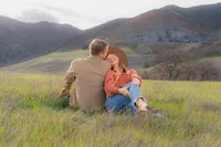 engagement photos in open field by water tower and mountain in bay area california