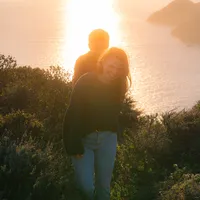 sunset couple photos on cliffside in san francisco during golden hour with dog