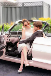 bride with sunglasses sitting on groom in classic car at hollins house in santa cruz