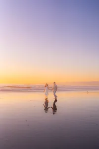 ocean couple running across santa cruz beach barefoot