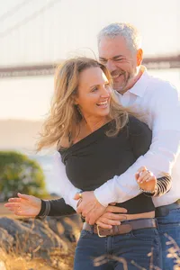 couple embracing sunset engagement photos by the golden gate bridge at cavallo point