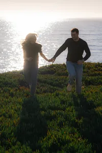 couple running on cliffside in santa cruz california