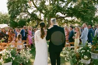 Father walks bride down the aisle during outdoor wedding ceremony