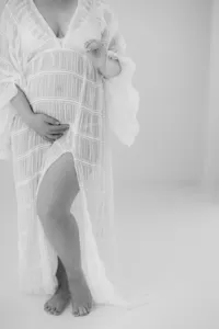 Black and white photo of pregnant woman during maternity portrait session in long dress by Suzanne Karp Photography