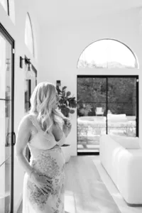 Black and white in-home photo of pregnant woman during maternity photo session by Suzanne Karp Photography