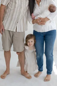 Family photo zoom of parents legs and daughter in between them both by Suzanne Karp Photography in Ross California