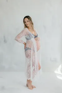 Pregnant woman wearing lace undergarments and lace dress during maternity session by by Suzanne Karp Photography