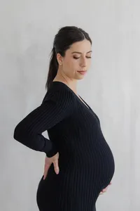 Pregnant woman in black maternity dress during portrait session by by Suzanne Karp Photography