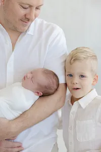 Close up of newborn and brother in white clothing at a studio session by Suzanne Karp Photography in Sausalito California