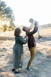 Mom, dad kid playing during an outdoor golden hour family photo session and by Suzanne Karp Photography in Napa California