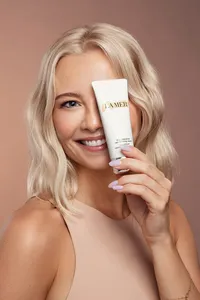Paulina Michaels in a beauty shot holding a luxury skincare product, exuding elegance, captured by Ylva Erevall.