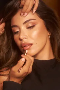 Andrea Veira showcasing glowing makeup in a close-up portrait for the Charlotte Tilbury campaign, captured by Ylva Erevall.