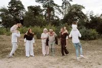 Kinderen zitten allemaal bij een volwassenen op de rug en rennen rond tijdens een familiefotoshoot