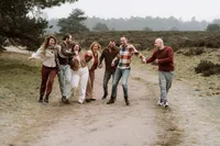 Familie kaatsen hun heupen tegen elkaar tijdens een fotoshoot met de familie in de omgeving Apeldoorn
