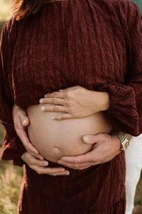 Close up foto van een zwangere buik met de handen van de vrouw en haar man tijdens een zwangerschapsshoot door Joenne Bokhorst Fotografie
