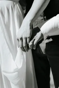 A close up of two people's ring fingers with rings tattooed on them.