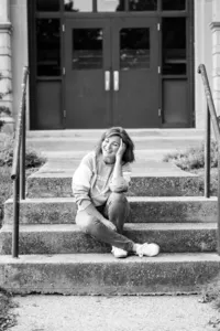 Heidi Peterson sitting on small set or stairs laughing