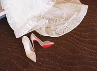 close up detail of louboutin shoes and wedding dress