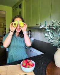 Dietitian Haley Miskowiec holding avocado halves over her eyes, sharing healthy fats for women preparing for pregnancy