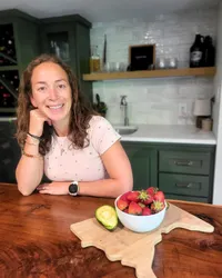 Haley Miskowiec, RD, headshot with fresh produce in her kitchen, ready to guide women on their journey to pregnancy