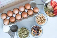 Protein-rich breakfast ingredients flat lay with eggs, chia seeds, pumpkin seeds, and nuts for women preparing for pregnancy