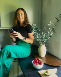 Haley Miskowiec, RD, on her kitchen counter beside fresh strawberries, sharing whole food nutrition for a healthy pregnancy
