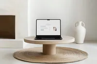 Laptop on a white oak coffee table showing a light and airy Showit website design