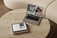 Laptop and iPad on a coffee table showing an elegant Showit template for photographers