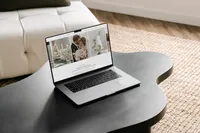 Laptop on dark coffee table showing an elegant Showit website design