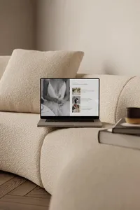 Laptop on a sofa showing an elegant Showit template for photographers