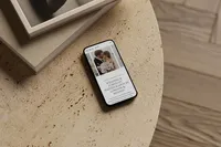 iPhone on a coffee table showing an elegant Showit template for photographers