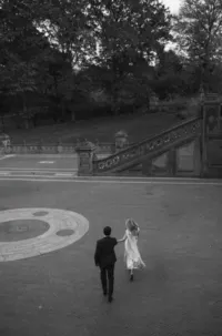 An engaged couple running through Bethesda Terrace in Manhattan.